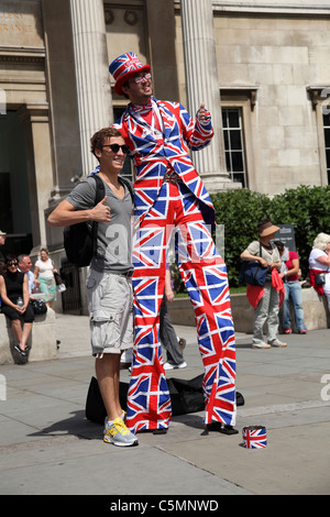 Ein Tourist, posiert für ein Foto mit einem Straßenkünstler in Trafalgar Square, London, England, UK Stockfoto