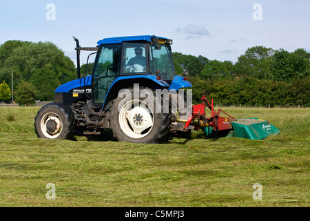 Mähen Heu mit einem New Holland TS90 4WD Trommel Traktor & eine Kverneland Taarup 1116 Mäher Stockfoto