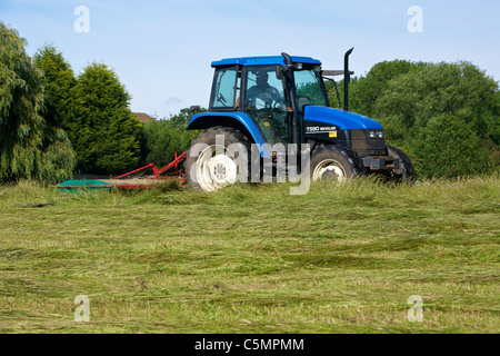 Mähen Heu mit einem New Holland TS90 4WD Trommel Traktor & eine Kverneland Taarup 1116 Mäher Stockfoto