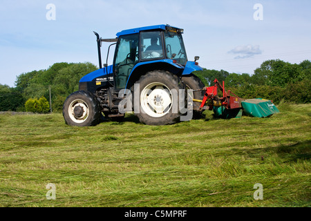 Mähen Heu mit einem New Holland TS90 4WD Trommel Traktor & eine Kverneland Taarup 1116 Mäher Stockfoto