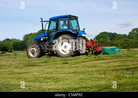 Mähen Heu mit einem New Holland TS90 4WD Trommel Traktor & eine Kverneland Taarup 1116 Mäher Stockfoto