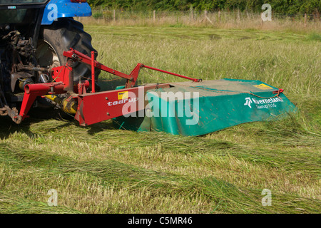 Mähen Heu mit einem New Holland TS90 4WD Trommel Traktor & eine Kverneland Taarup 1116 Mäher Stockfoto