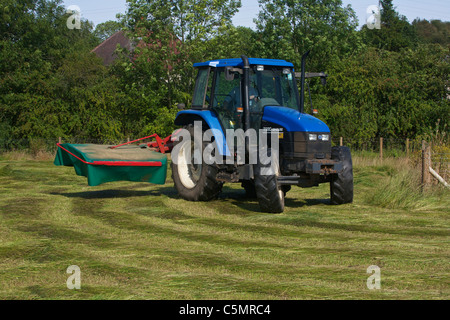 Mähen Heu mit einem New Holland TS90 4WD Trommel Traktor & eine Kverneland Taarup 1116 Mäher Stockfoto