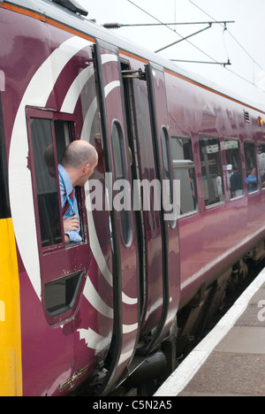 East Midlands Züge (EMT) Zug 158813 158-Klasse in Grantham Bahnhof auf Weg nach Norwich mit Fahrer aus Fenster gelehnt Stockfoto