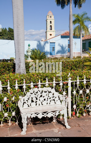 Kuba, Trinidad. Schmiedeeisen-Stuhl in der Plaza de Armas. Glockenturm der Kirche und Kloster von San Francisco im Heck. Stockfoto