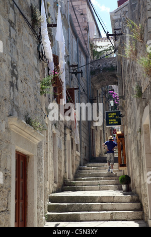 Ein Tourist bis zu Fuß einen abgestuften schmale Gasse in Insel Korcula, Dalmatien, Kroatien Stockfoto