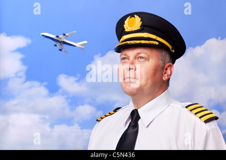 Foto von einem Airline-Piloten tragen vier bar Kapitäne Epauletten, erschossen vor dem Himmelshintergrund mit Jumbo Jet abheben Stockfoto