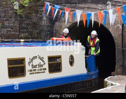 Ein Narrowboat entsteigt tonnelle Tunnel auf der Huddersfield Narrow Canal in Colne Valley, West Yorkshire, Großbritannien Stockfoto