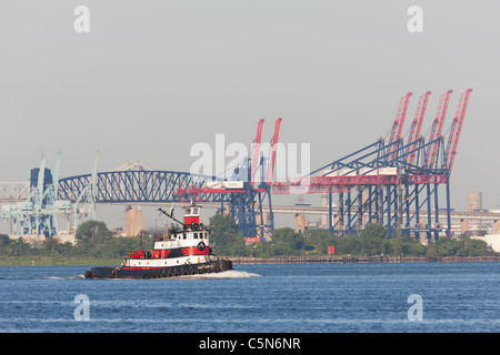 Norfolk Tug Schlepper "Kapitän D' in Newark Bay, mit die Containerbrücken des Containerterminals New York im Hintergrund. Stockfoto