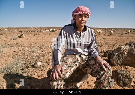 Ein Hirtenjunge Beduinen und Schafe in der Nähe der Stadt Deyr al-Kahf in der Badia Wüste Nordjordanien. Stockfoto