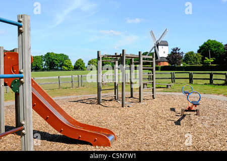 Spielplatz Rutsche und Klettergerüst in eingezäunt Kinderspielplatz auf Village Green mit Mountnessing post Mühle Mühle Brentwood Essex England UKUK Stockfoto