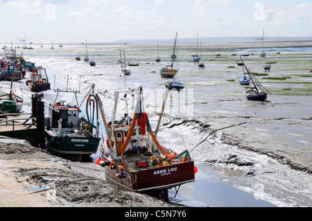 Fischboote mit Muscheln und Muscheln, die in der Themse-Mündung auf Schlammflächen im Ebbe des Old Leigh Essex Coast Kent Coastline und Boote im fernen England, Großbritannien, liegen Stockfoto