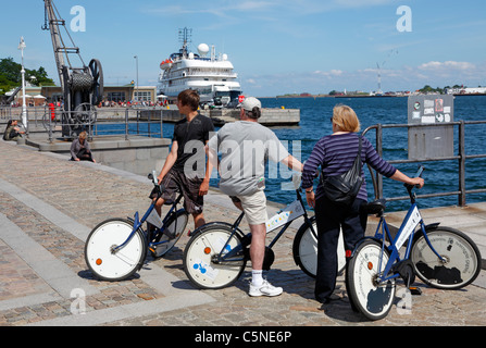 Touristen genießen Sightseeing am sonnigen Sommertag im Hafen von Kopenhagen Radfahren auf den kostenlosen Kopenhagen Citybikes. Toldboden, Kopenhagen, Dänemark. Stockfoto