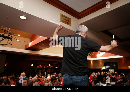 Manchester Utd inoffizielle Songschreiber Peter Boyle führt das Singen von Manchester United Fans in der Bischof Blaize Kneipe. Stockfoto