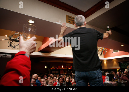 Manchester Utd inoffizielle Songschreiber Peter Boyle führt das Singen von Manchester United Fans in der Bischof Blaize Kneipe. Stockfoto