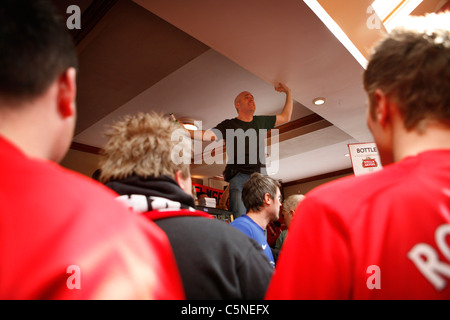 Manchester Utd inoffizielle Songschreiber Peter Boyle führt das Singen von Manchester United Fans in der Bischof Blaize Kneipe. Stockfoto