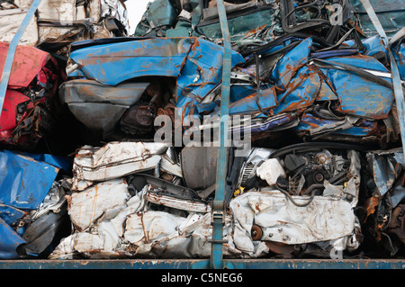 Ein Haufen von zerkleinerten Karosserien festgeschnallt auf einem Transporter. Stockfoto