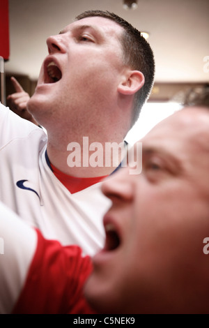 Manchester Utd inoffizielle Songschreiber Peter Boyle führt das Singen von Manchester United Fans in der Bischof Blaize Kneipe. Stockfoto