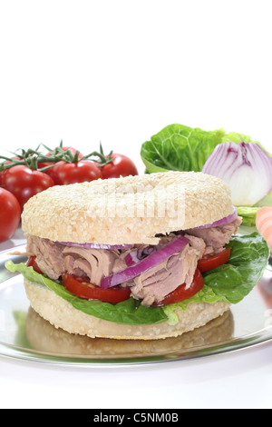 Bagel mit Thunfisch, Tomaten, Zwiebeln und Salat auf weißem Hintergrund Stockfoto