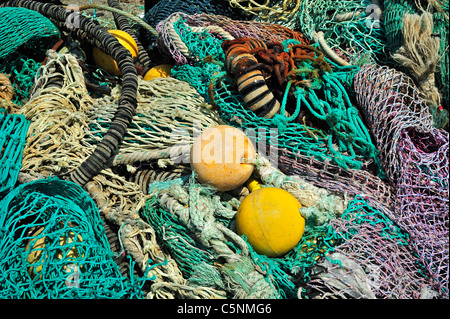 Haufen bunter Schleppnetzfischerei Fischernetze und schwimmt auf dem Kai am Hafen von Guilvinec, Finistère, Bretagne, Frankreich Stockfoto