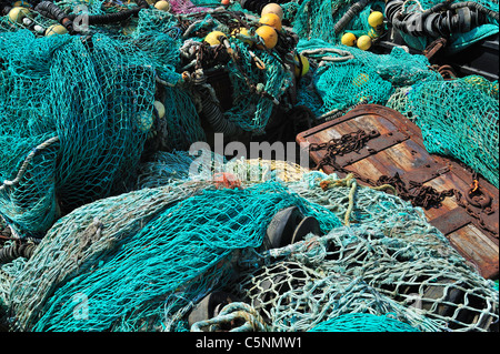 Haufen bunter Schleppnetzfischerei Fischernetze und schwimmt auf dem Kai am Hafen von Guilvinec, Finistère, Bretagne, Frankreich Stockfoto