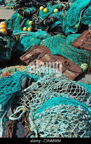 Haufen bunter Schleppnetzfischerei Fischernetze und schwimmt auf dem Kai am Hafen von Guilvinec, Finistère, Bretagne, Frankreich Stockfoto