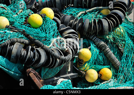 Haufen bunter Schleppnetzfischerei Fischernetze und schwimmt auf dem Kai am Hafen von Guilvinec, Finistère, Bretagne, Frankreich Stockfoto