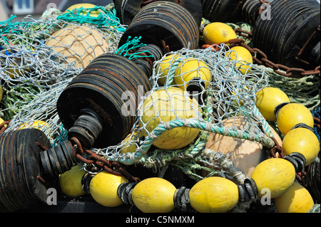 Haufen bunter Schleppnetzfischerei Fischernetze und schwimmt auf dem Kai am Hafen von Guilvinec, Finistère, Bretagne, Frankreich Stockfoto