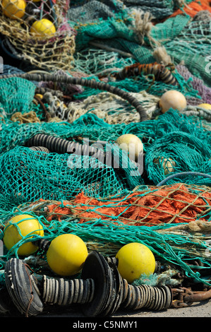 Haufen bunter Schleppnetzfischerei Fischernetze und schwimmt auf dem Kai am Hafen von Guilvinec, Finistère, Bretagne, Frankreich Stockfoto