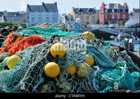 Haufen bunter Schleppnetzfischerei Fischernetze und schwimmt auf dem Kai am Hafen von Guilvinec, Finistère, Bretagne, Frankreich Stockfoto