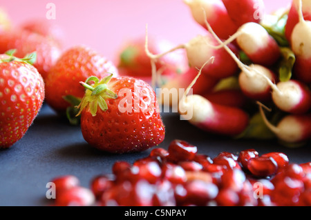 Rote Früchte und Gemüse: Erdbeeren, Radieschen und Granatapfel Stockfoto