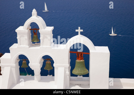 Bell Tower der griechisch-orthodoxen Kirche und Segelboote über in Oia, Santorin, die Kykladen-Griechenland Stockfoto