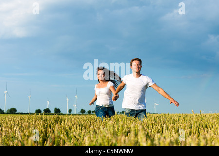Glückliches Paar überfahren Grainfield im Sommer einher Stockfoto