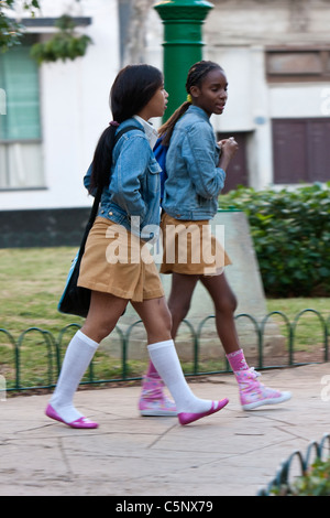 Kuba, Havanna. Kubas Nachwuchs. Zwei Mädchen im Teenageralter zur Schule zu gehen. Ocker-gelb Röcke zeigen Sekundarstufe. Stockfoto