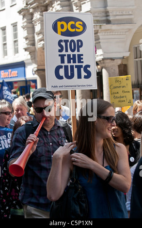 Demonstrant eine Vuvuzela bläst und hält ein Plakat des PCS an den Streikenden Marsch durch Exeter City Centre. Stockfoto