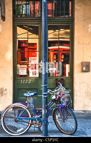 Fahrrad mit Karneval Perlen verziert gesperrt, um einen Beitrag über eine typische Straße der French Quarter in New Orleans. Stockfoto