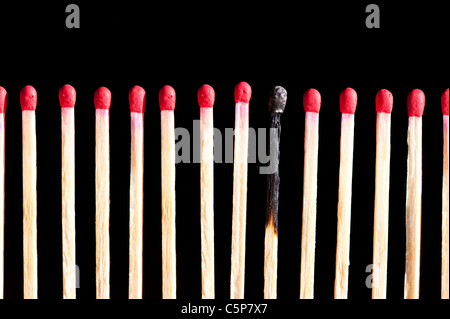 eine Reihe von Übereinstimmungen mit einem verbrannten, isoliert auf schwarzem Hintergrund Stockfoto