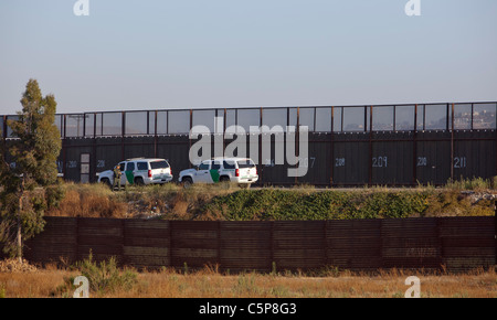 San Ysidro, Kalifornien - Border Patrol Agenten durch den Zaun, der San Ysidro von Tijuana, Mexiko trennt geparkt. Stockfoto