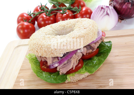 Bagel mit Thunfisch, Tomaten, Zwiebeln und Salat auf weißem Hintergrund Stockfoto