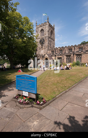 Holy Trinity Church, Skipton - Freunde sitzen, entspannen, Wandern in sonnigen Kirchgarten & Namensschild durch Eingangswege (Yorkshire, England, UK). Stockfoto