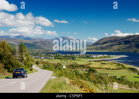 Auto auf der der A835 Hauptstraße mit Blick über Ullapool und Loch Broom, Ross und Cromarty, Highland, Schottland, Vereinigtes Königreich Stockfoto