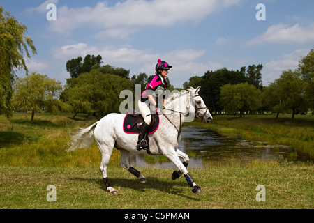 Cross Country Lakeside Galopp, Agilität, Wettbewerb, Kurs, Reiten, Pferd, springen, springen, Rennen, Erfolg, Wettbewerb, Galopp, Galopp, Pferd, Pferd, Säugetier, Bewegung, Reiter, reiten, zeigen, Geschwindigkeit, Splash, Spray, Turnier, Cross Country, Event, reiten, Sport, Tier, Land, Gras, in Bewegung, Natur, im Freien, Wasser, Land Reiten auf dem Cholmondeley Castle Horse Trials, UK, 2011, Cheshire Stockfoto