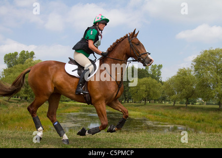 Cross Country Lakeside Galopp, Agilität, Wettbewerb, Kurs, Reiten, Pferd, springen, springen, Rennen, Erfolg, Wettbewerb, Galopp, Galopp, Pferd, Pferd, Säugetier, Bewegung, Reiter, reiten, zeigen, Geschwindigkeit, Splash, Spray, Turnier, Cross Country, Event, reiten, Sport, Tier, Land, Gras, in Bewegung, Natur, im Freien, Wasser, Land Reiten auf dem Cholmondeley Castle Horse Trials, UK, 2011, Cheshire Stockfoto