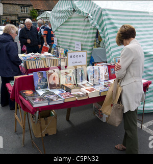 Shopper in einem Buch stand am Freitag Wochenmarkt auf dem Platz am Helmsley North Yorkshire Stockfoto