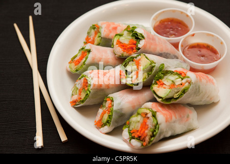 Horizontale Ansicht von Garnelen Frühlingsrollen mit süßer Chilisauce, neben Stäbchen. Stockfoto