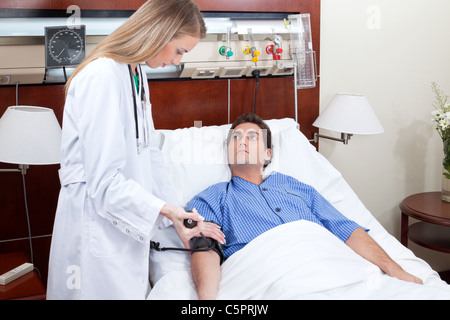 Arzt überprüft den Blutdruck des Patienten im Krankenhaus Stockfoto