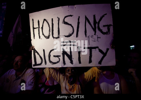 Ein afrikanischer Asylbewerber hält Plakat während eines Protestes gegen Steigende Immobilienpreise und soziale Ungleichheiten in Tel Aviv, Israel Stockfoto