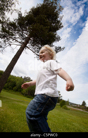 Ein junges Kleinkind junge läuft außerhalb in einem ländlichen Bauernhof-Ambiente Stockfoto