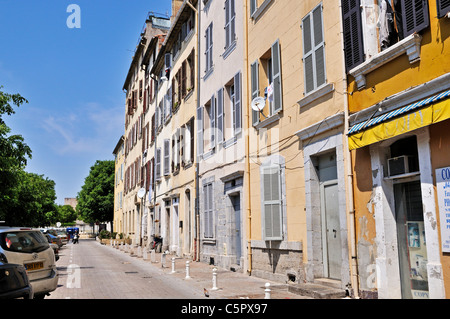 Typische alte französische s Häuser und Wohnungen in einer Cobble Stone Gasse gesäumt von kleinen weißen Poller, Toulon Stockfoto