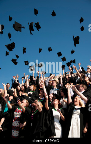 Eine Gruppe von Aberystwyth Universität Absolventen am Abschlusstag, werfen ihre Mützen in die Luft, UK Stockfoto